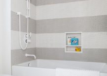 White and gray penny shower tiles in a stripe pattern design in a bathtub white shower kit