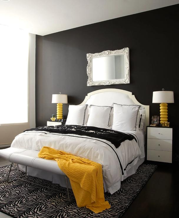 yellow black and white bedroom color scheme with lamps and nightstands mirror above bed zebra carpet