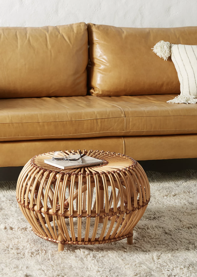 rattan ottoman next to light leather brown couch