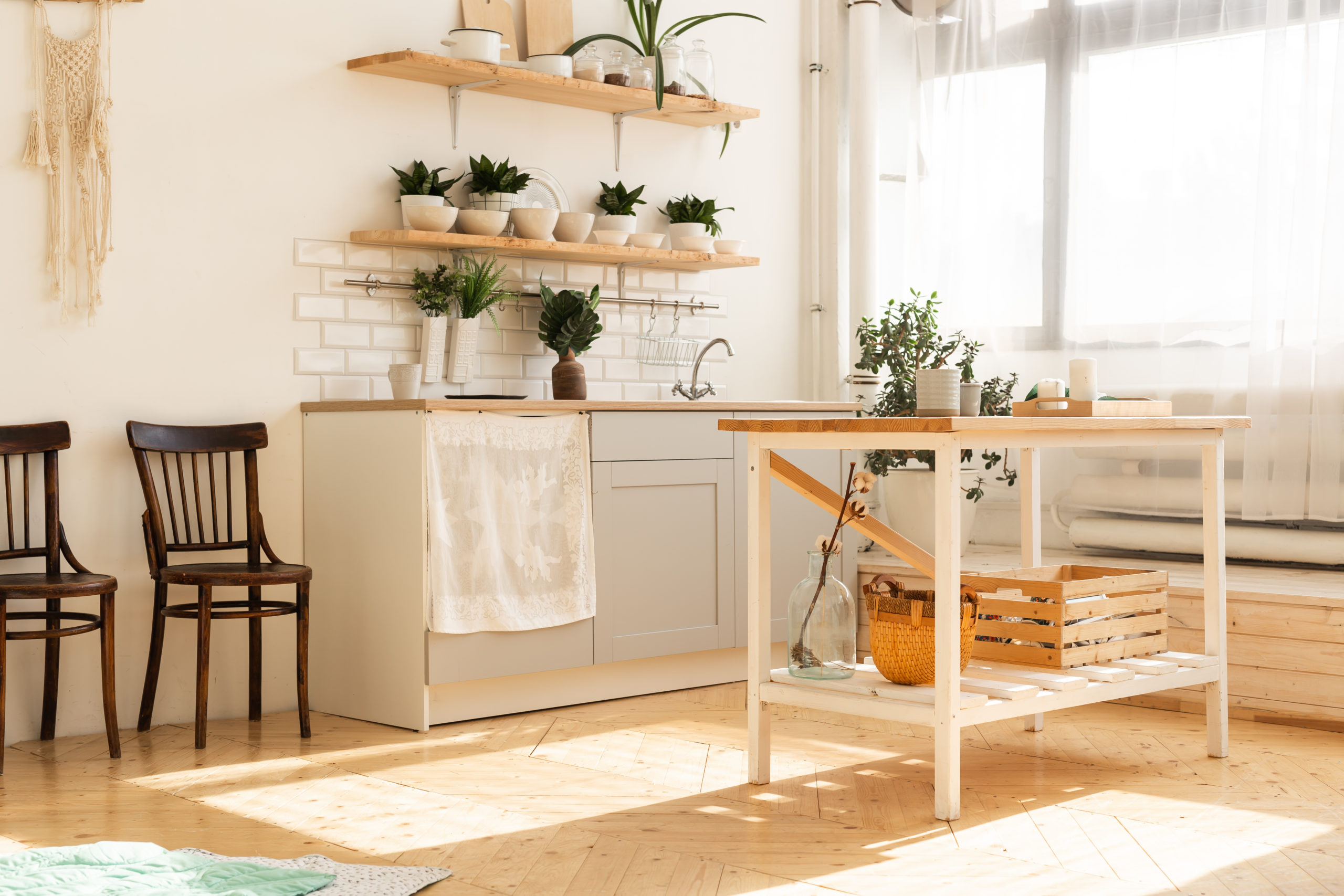 sheer curtains in open space Scandinavian kitchen with plants on open shelving small wood island in middle