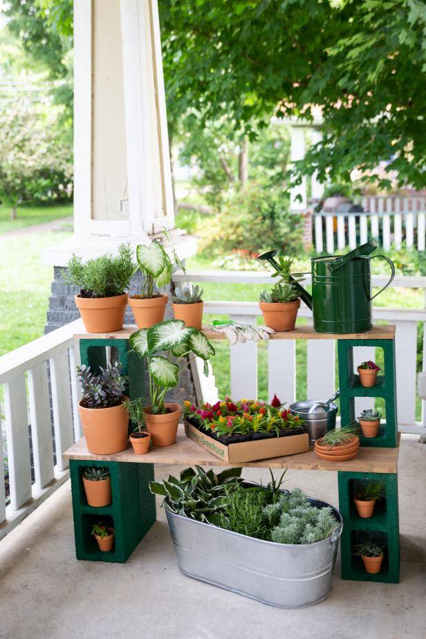 cinder block outdoor plant stand with terracotta pots on porch