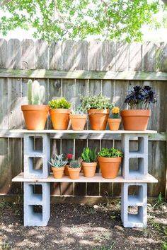 ice blue painted cinder blocks turned into a potting shelf with terracotta pots on it