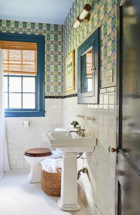 half bathroom with color framed window blue pedestal sink with bold wallpaper