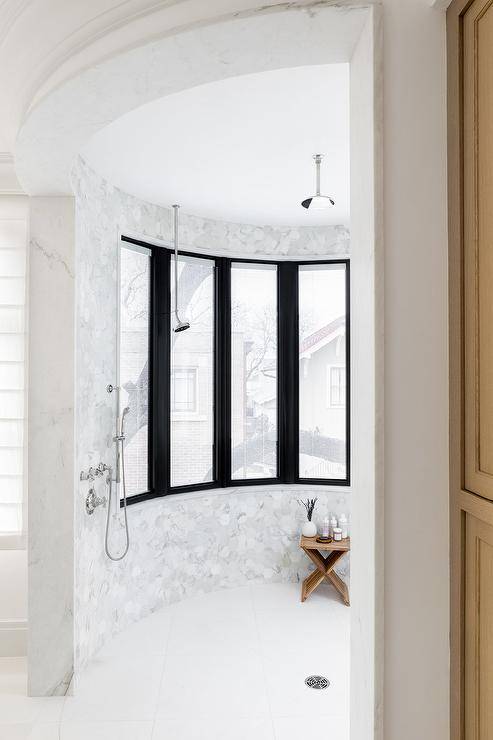 curved walk in shower with black frame windows and no doors