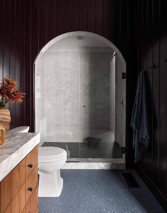 black wall vertical shiplap around a curved shower walk in with glass doors