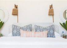 Rope Hanging Wall Pendants above a light gray headboard fitted with pink and blue pillows on white bedding flanked by white ceramic vases and greenhouse plants.