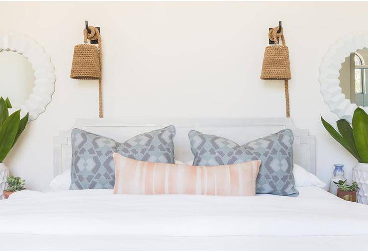 Rope Hanging Wall Pendants above a light gray headboard fitted with pink and blue pillows on white bedding flanked by white ceramic vases and greenhouse plants.