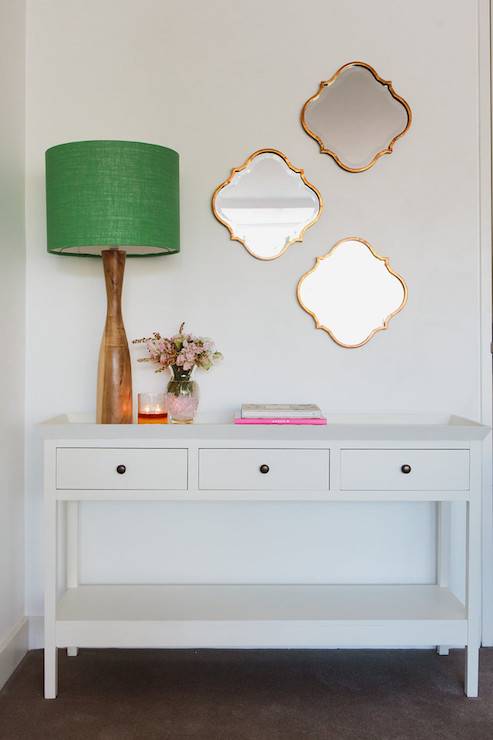 three gold mirrors entryway table green shade lamp