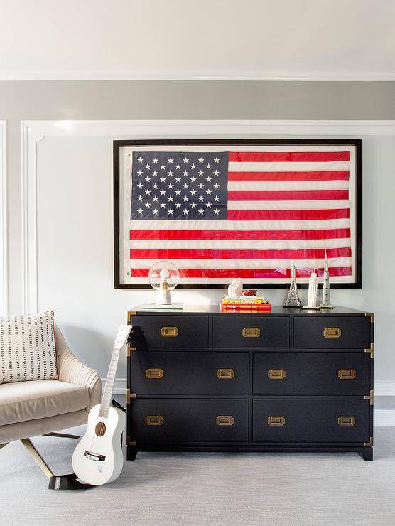 framed america flag hanging above dark navy blue dresser chair and guitar