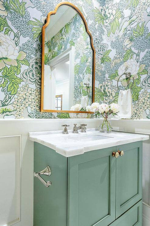 green vanity with floral wallpaper and gold arch mirror flowers white marble top sink