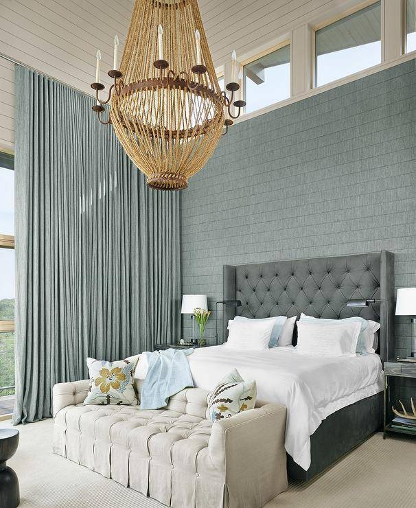 grey and blue bedroom decor large chandelier white sofa at end of bed tufted headboard
