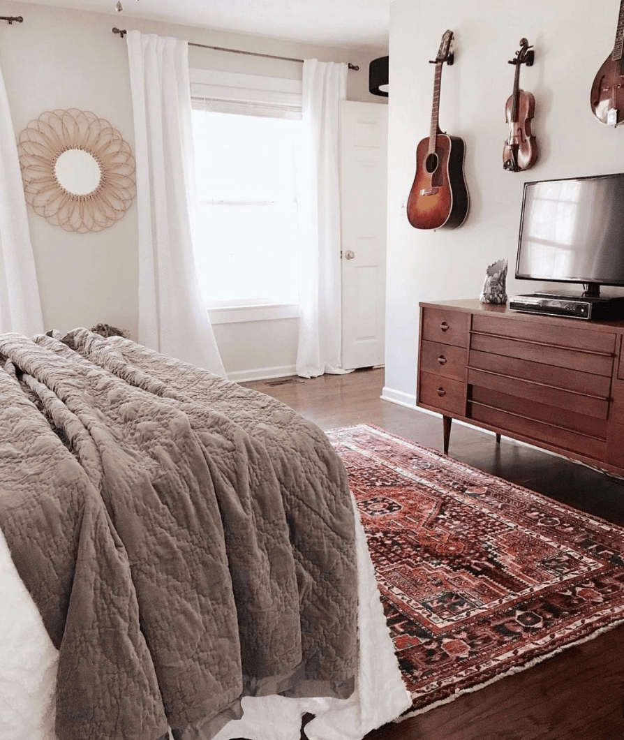 hanging guitar and violins in bedroom on white walls mirror television