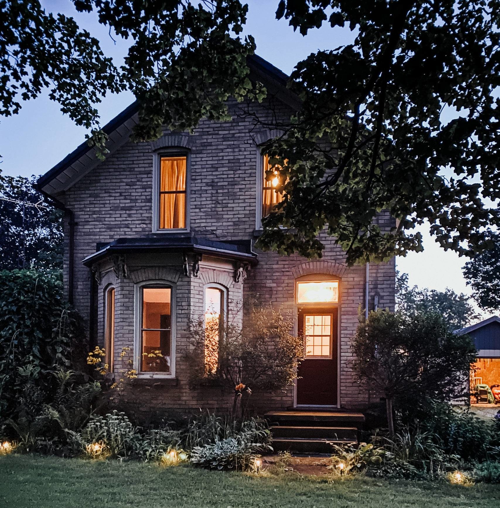 old victorian home lit up a night