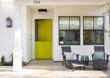 A stunning white home is accented with a neon yellow Dutch front door finished with a modern door knob.