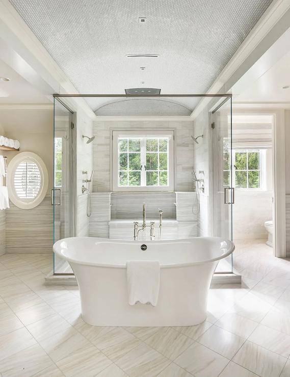 shower in middle of room glass doors all sides tile tub in middle oval white