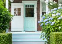 Beautiful cottage features mint green front door alongside steps painted to match.