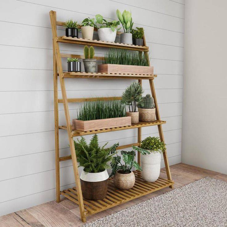 bamboo outdoor plant stand with greenery leaning against white shiplap wall