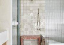 white ceramic wall tile walk in shower with red marble waterfall bench