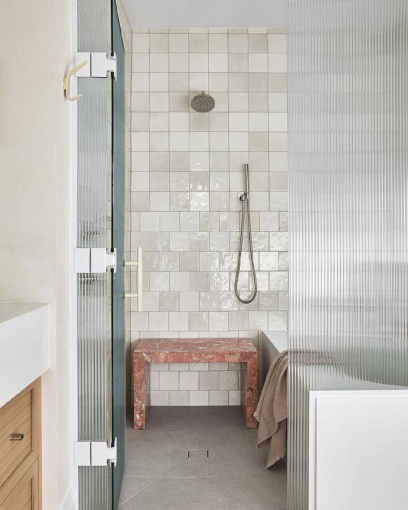 white ceramic wall tile walk in shower with red marble waterfall bench