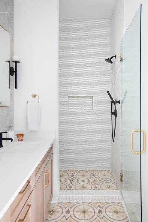 modern white walk in shower with black shower kit white counter vanity and patter mosaic floor tile