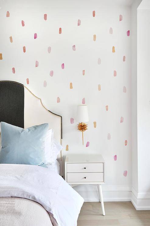 Wallpaper polka dot pink pastel dengan tempat tidur dan meja samping tempat tidur