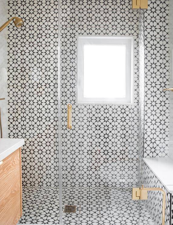 black and white sunburst tiles walk in shower with glass doors and gold hardware