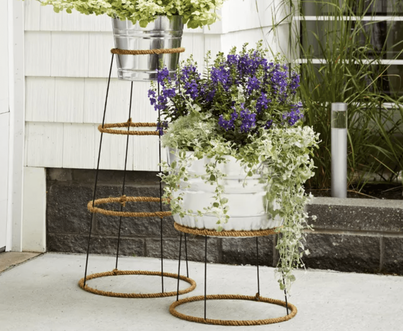 plant stand close up made out of tomato cages wrapped in jute twine with planters on top