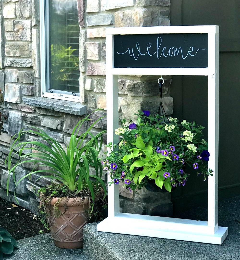 white frame welcome hanging plant stand with hanging pot