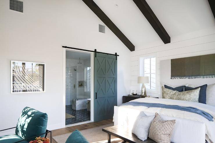 A blue mullion door on rails opens to an en suite master bathroom.