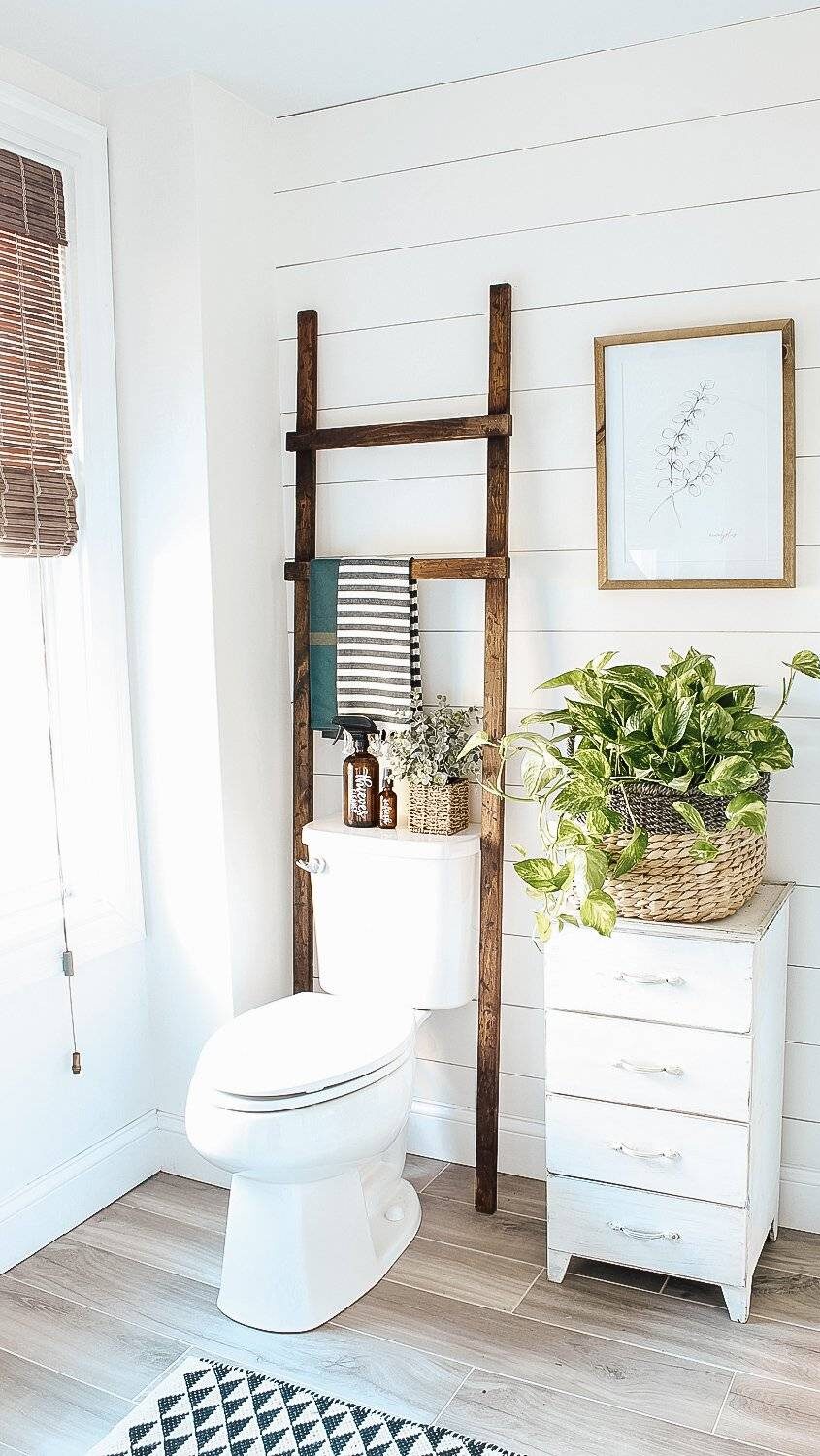 white shiplap wall bathroom ladder over toilet white four drawer shelf with potted plant