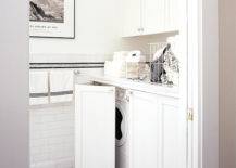 Laundry room with hidden washer and dryer, Front load washer and dryer hidden behind folding shaker cabinets doors. Laundry room with marble countertops, subway tile backsplash and marble basketweave tiles floor.