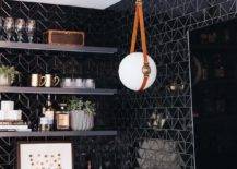Contemporary wet bar features glossy black geometric tiles, black floating shelves and a flatscreen TV illuminated by a white glass and leather sphere pendant.