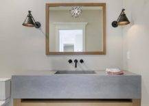 Amazing bathroom features a Moravian Star pendant suspended over a square wood mirror and wood washstand with a thick concrete sink.