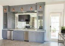 blue cupboards wet bar with television mirrored subway tiles