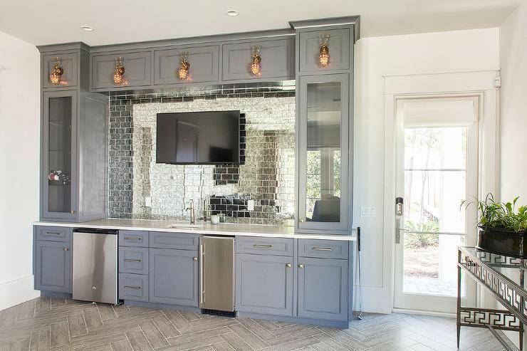 blue cupboards wet bar with television mirrored subway tiles