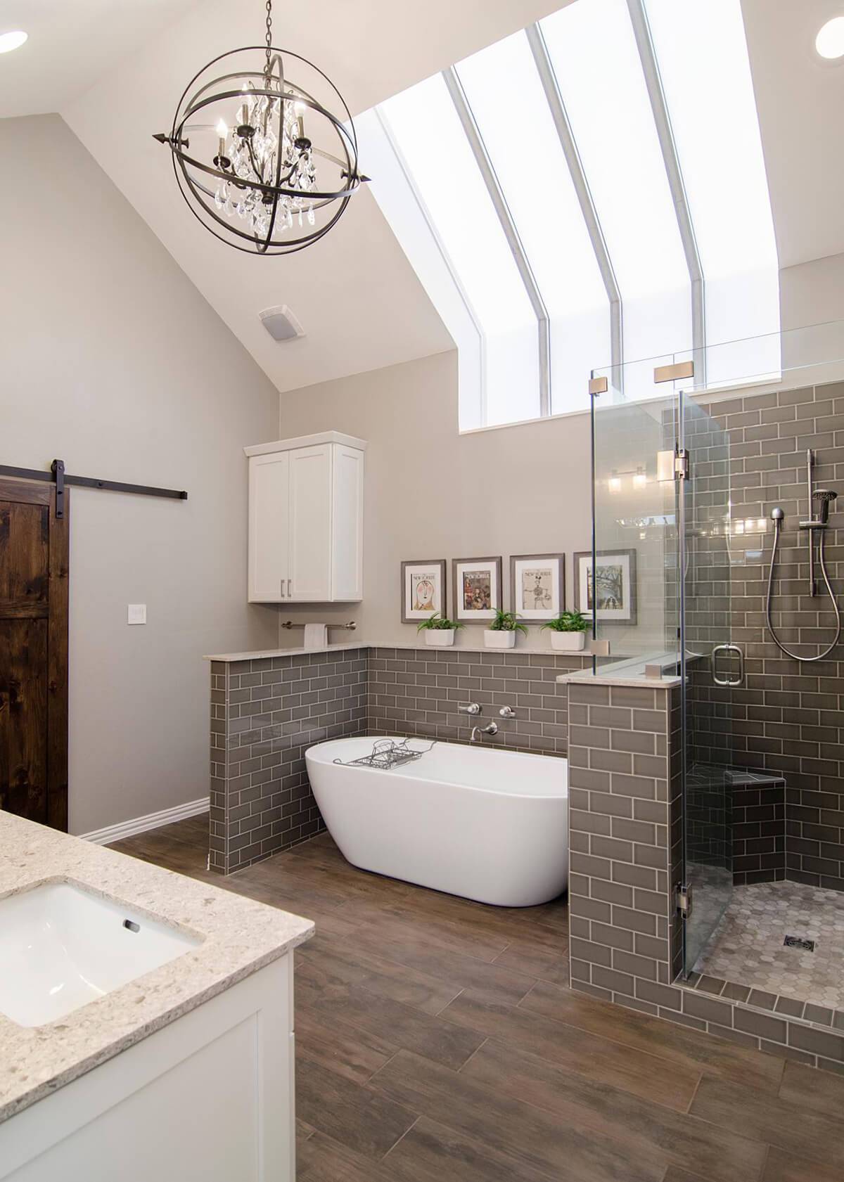 large master bathroom with dark grey subway tile surround walk in shower free standing tub