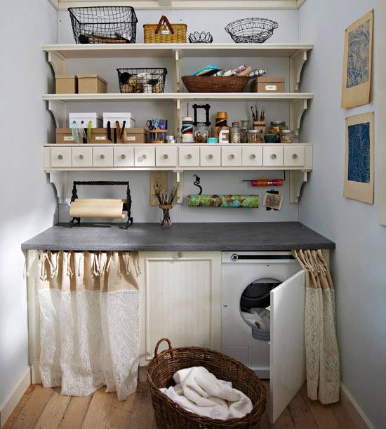 Vintage laundry room with skirted table, white washer, concrete countertop, ivory shelves and blue walls paint color.