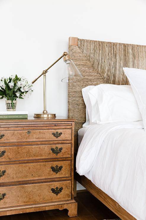 Beach cottage bedroom fitted with a natural woven headboard flanked by a set of vintage nightstands displaying the gold and brass task lamps.