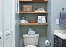 wall to wall floating wood shelves hung in between walls and over white toilet