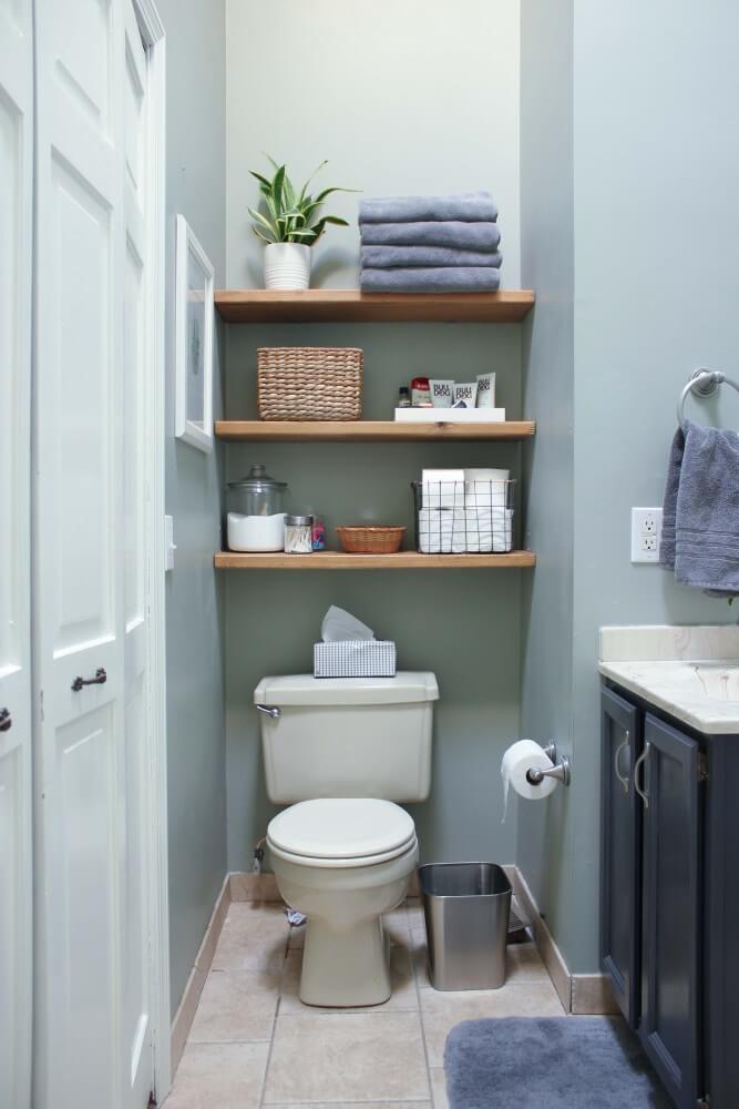 wall to wall floating wood shelves hung in between walls and over white toilet