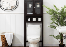 black over the toilet storage hutch white toilet greenery tropical plant basket oval black mirror