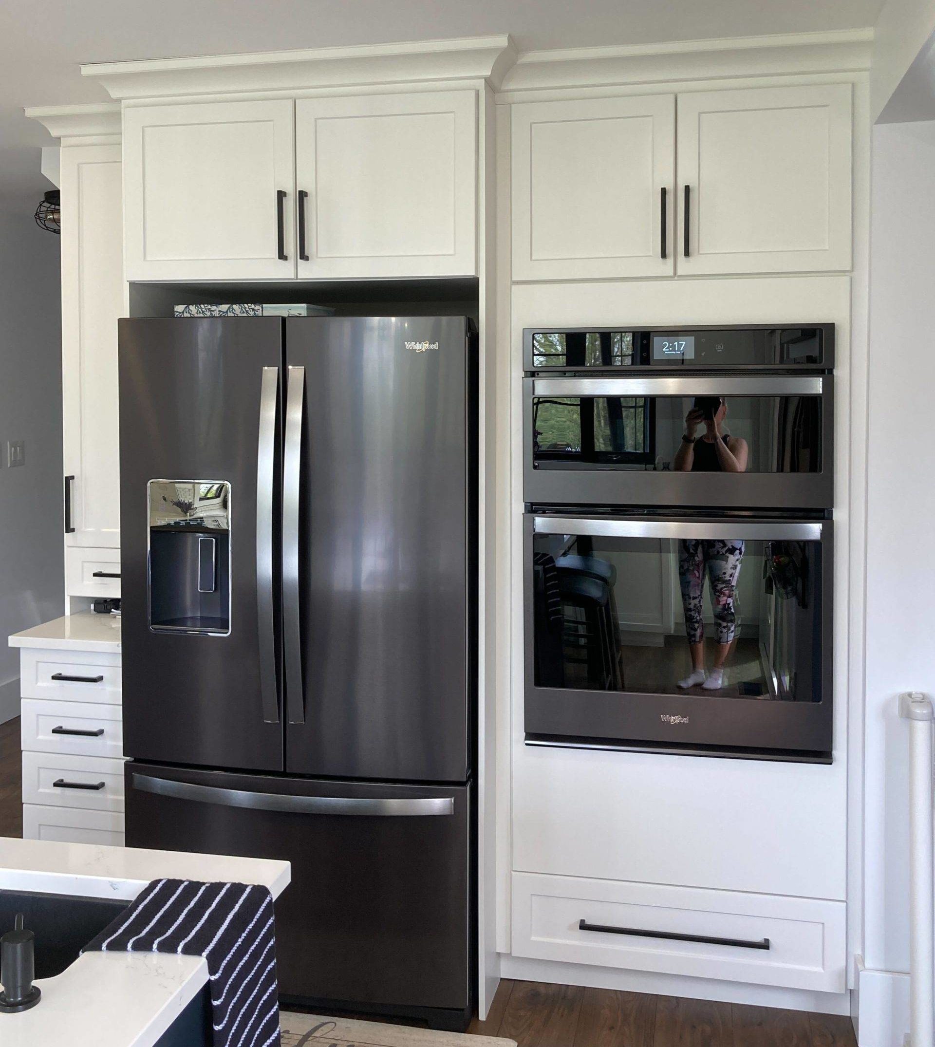 black stainless steel kitchen appliances against white cabinets