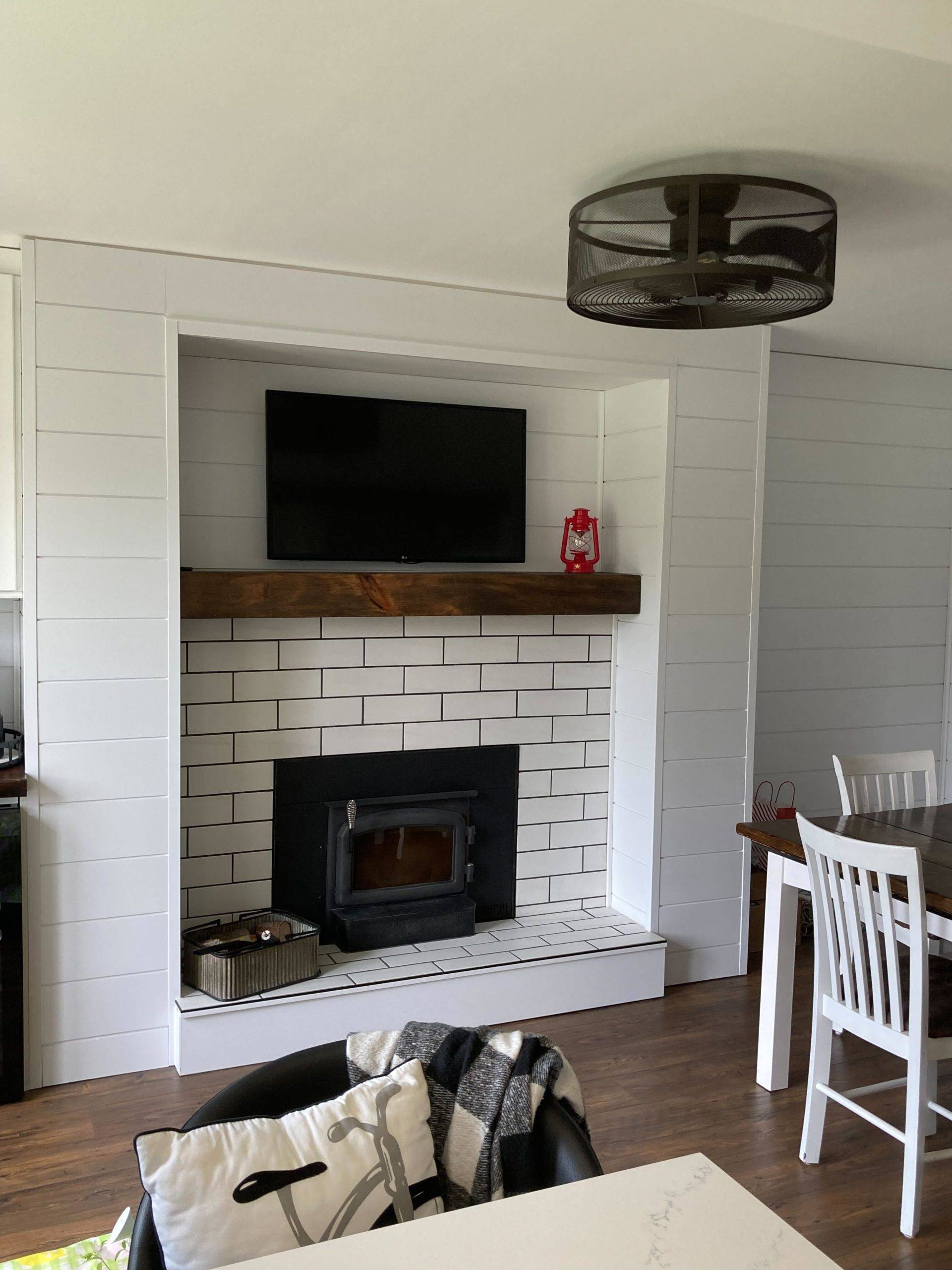 white brick fireplace with wooden mantel