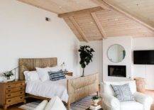 Beach cottage master bedroom boasts a light stained plank ceiling above a natural woven bed dressed with white bedding. Vintage nightstands are styled with a glass and brass task lamp adding a contemporary touch completing the rooms aesthetic.