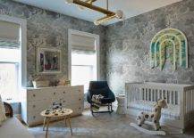 Contemporary boy's nursery features Fornasetti Nuvole gray clouds wallpaper, a white modern crib under art, a black nursery rocker, a white dresser, a round accent table and a rocking horse.