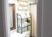 open wire rack shelving over toilet storage in farmhouse decorated bathroom