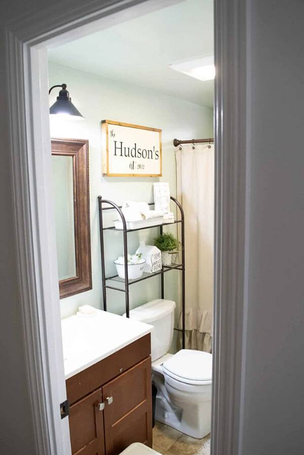 open wire rack shelving over toilet storage in farmhouse decorated bathroom