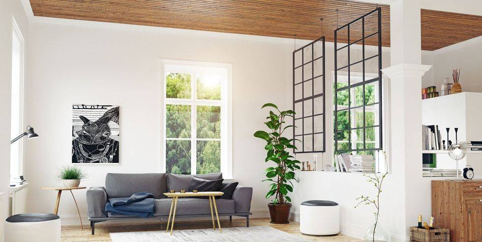 white living room with grey couch modern slender coffee table and two 18 pan windows hanging from ceiling separating off living room from kitchen