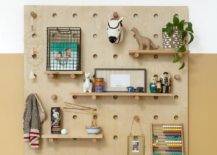 Boy nursery peg wall organizer on a mustard yellow nursery wall features vintage wood toys and fun accenting decor.