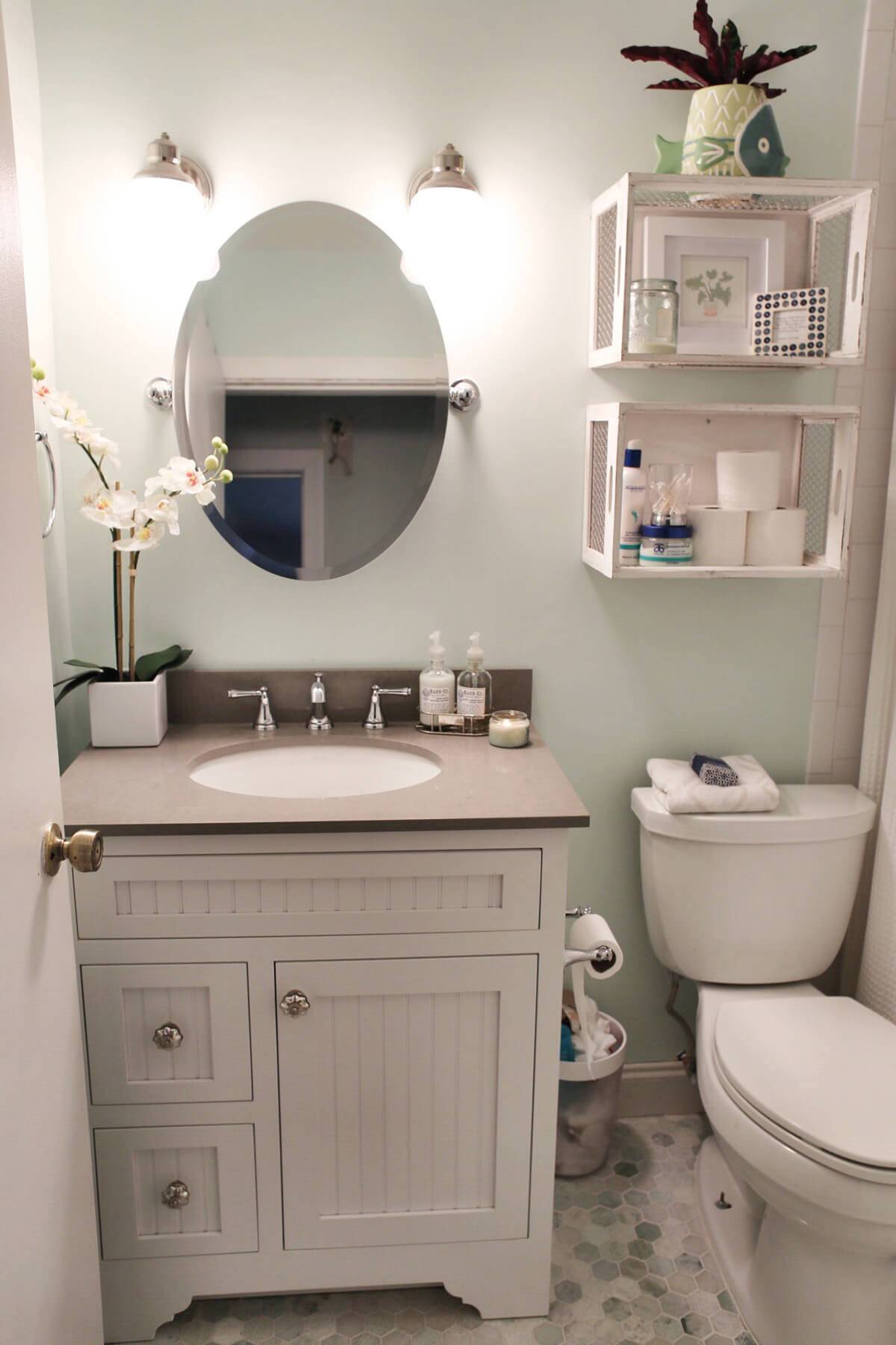 white vanity in bathroom repurposed crates storage over the toilet oval mirror with wall sconces